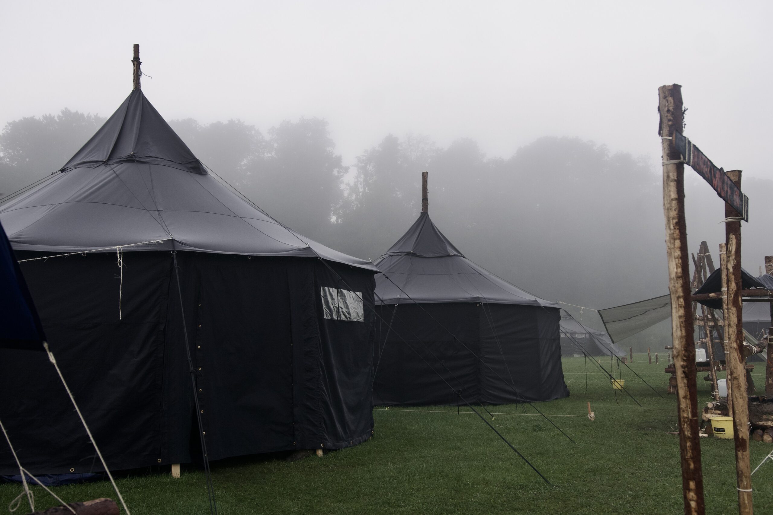 Mehrere große schwarze Zelte auf einer nebligen Wiese, geeignet für Gemeinschaftsveranstaltungen und Outdoor-Gottesdienste bei ICF Balingen.