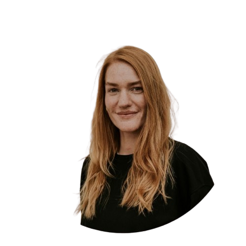 Frau mit langen roten Haaren bei einer ICF Berlin Veranstaltung, lächelnd und freundlich, in einem schwarzen Oberteil, vor einem neutralen Hintergrund.