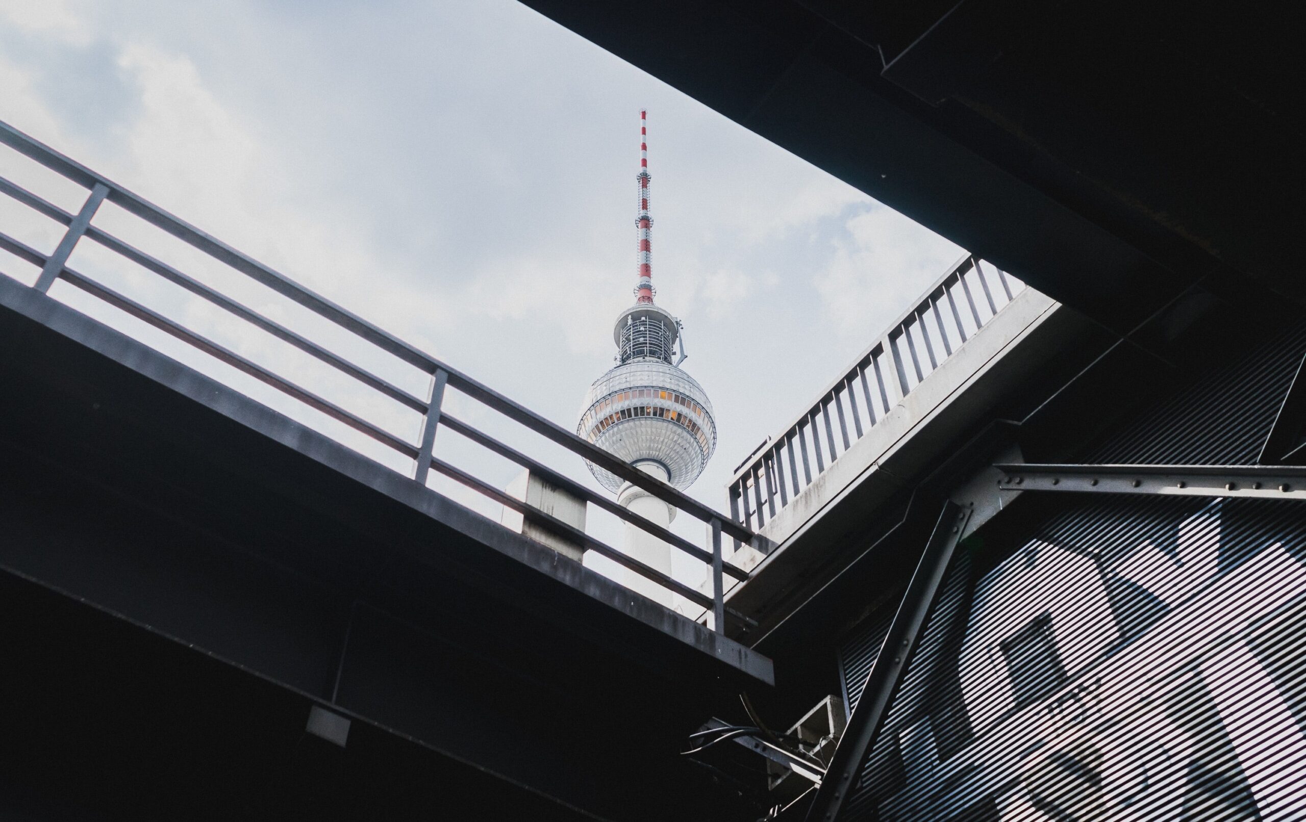 Berlin Fernsehturm im Blick, sichtbar durch eine moderne Gebäudestruktur, symbolisiert die Verbindung von Stadtentwicklung und Innovation. Perfekt für christliche Gemeinschaftsveranstaltungen in Berli.