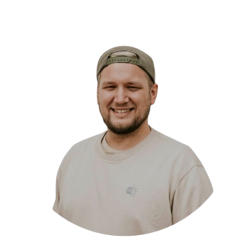 Lächelnder Mann in casual Kleidung bei ICF Berlin, repräsentiert Gemeinschaft und positive Atmosphäre.