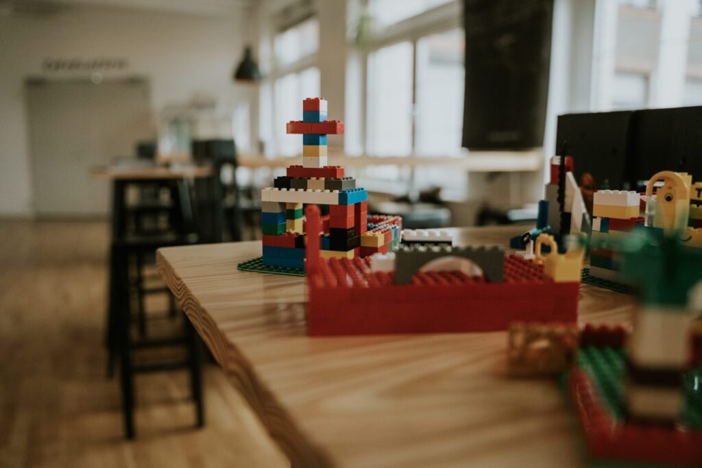 Kinderspielzeug aus bunten LEGO-Steinen auf einem Tisch im Gemeindesaal, ideal für Kinderaktivitäten und kreative Spiele bei ICF Berlin.