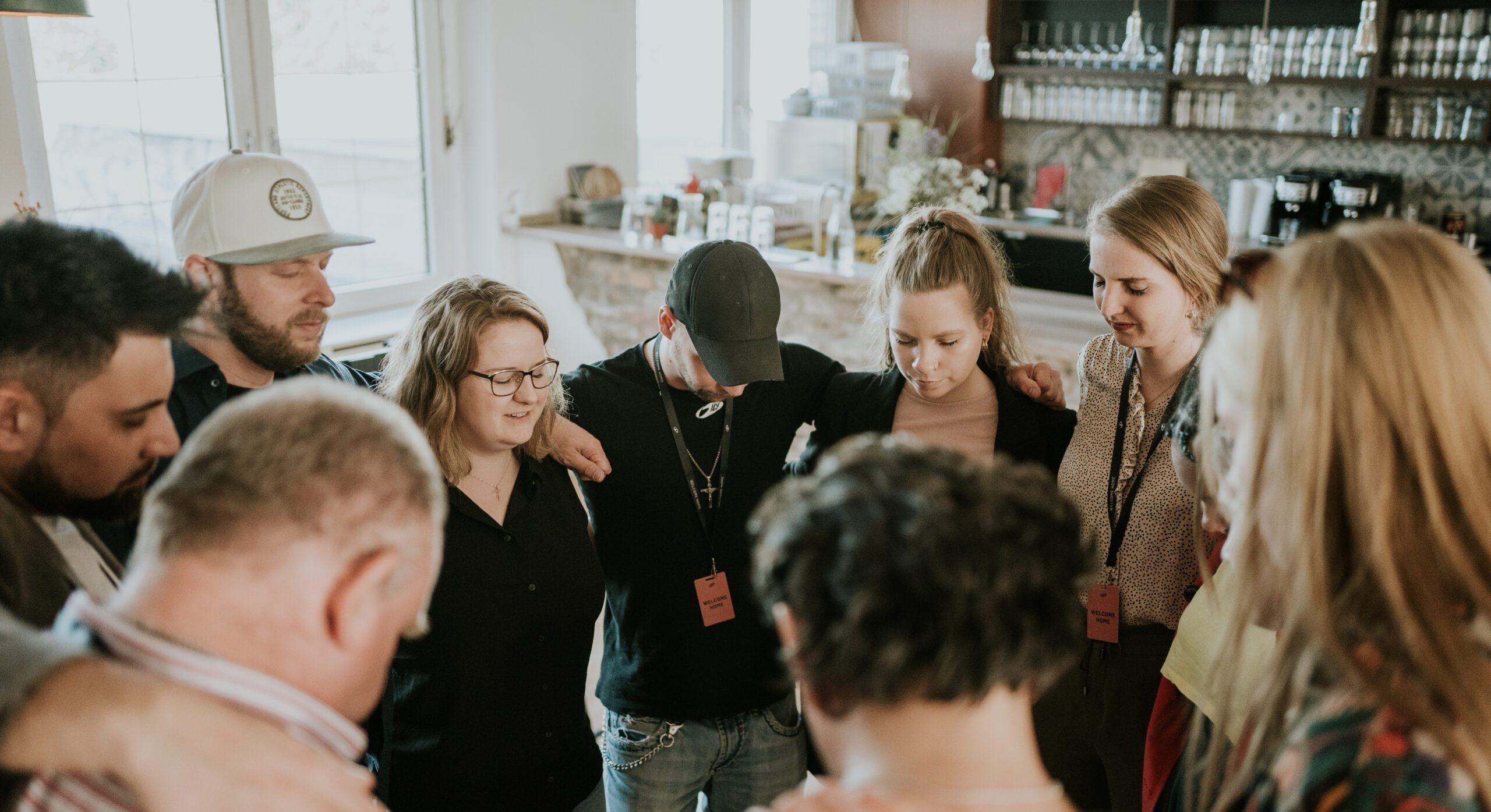 Gruppe von Menschen beim Gebet in einer Kirche in Berlin, die Gemeinschaft und Spiritualität zeigt.