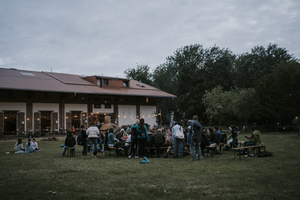 Menschen versammeln sich im Freien vor einem Gebäude bei einem Festival.