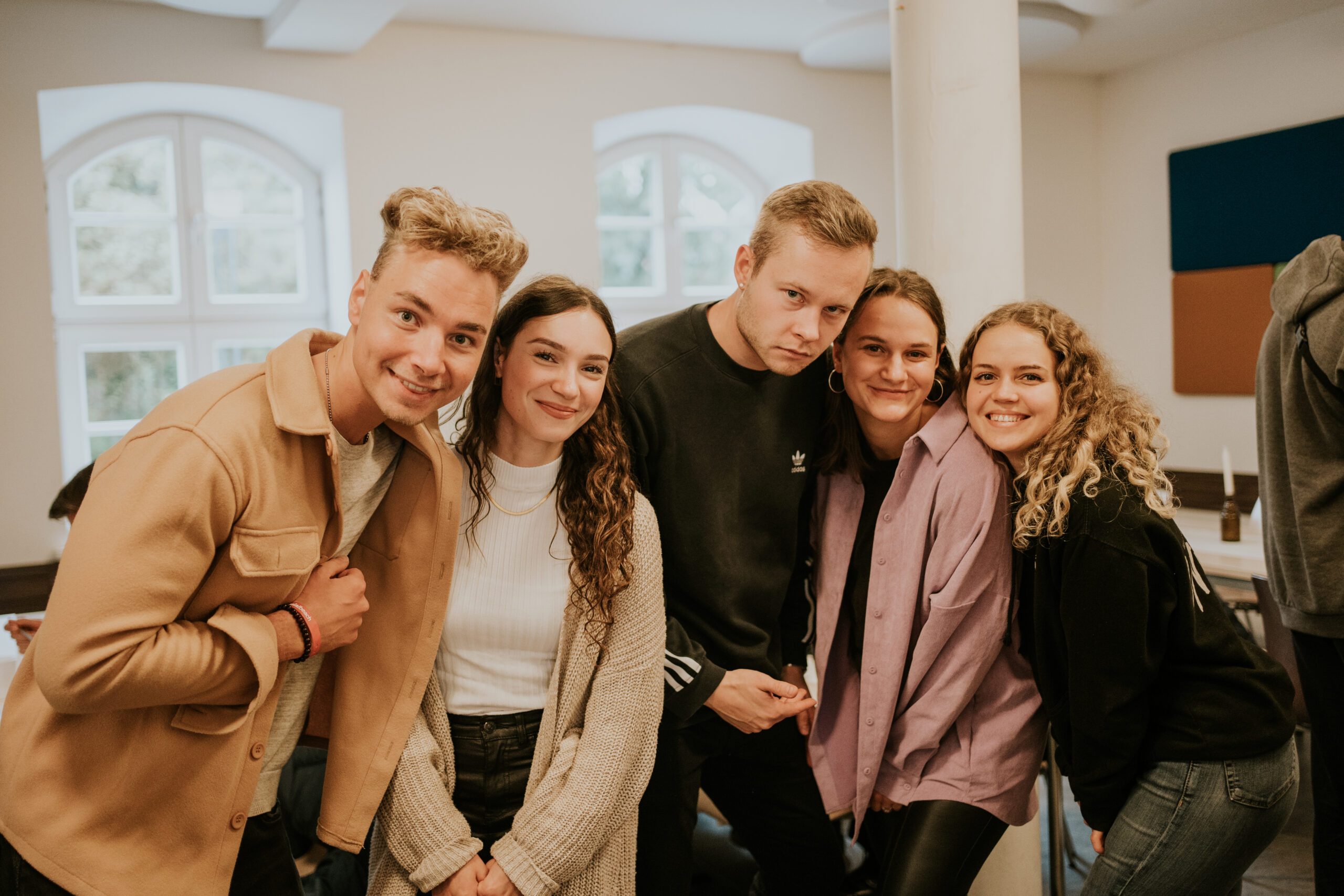 Gruppe junger Menschen bei ICF Berlin, die gemeinsam lachen und sich freuen, symbolisiert Gemeinschaft und positive Atmosphäre in der Kirche.