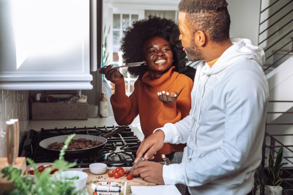 Eine Frau und ein Mann kochen zusammen in der Küche.