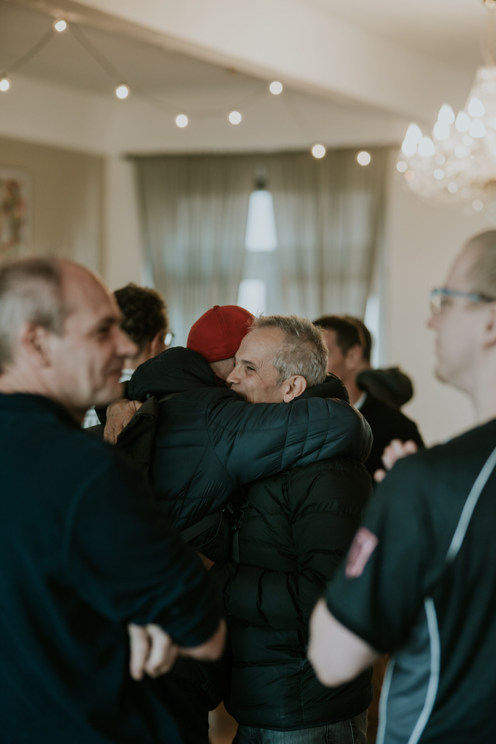 Menschen bei ICF Berlin begrüßen sich herzlich in einem hellen, modernen Raum, der für Gemeinschaftsveranstaltungen gestaltet ist.