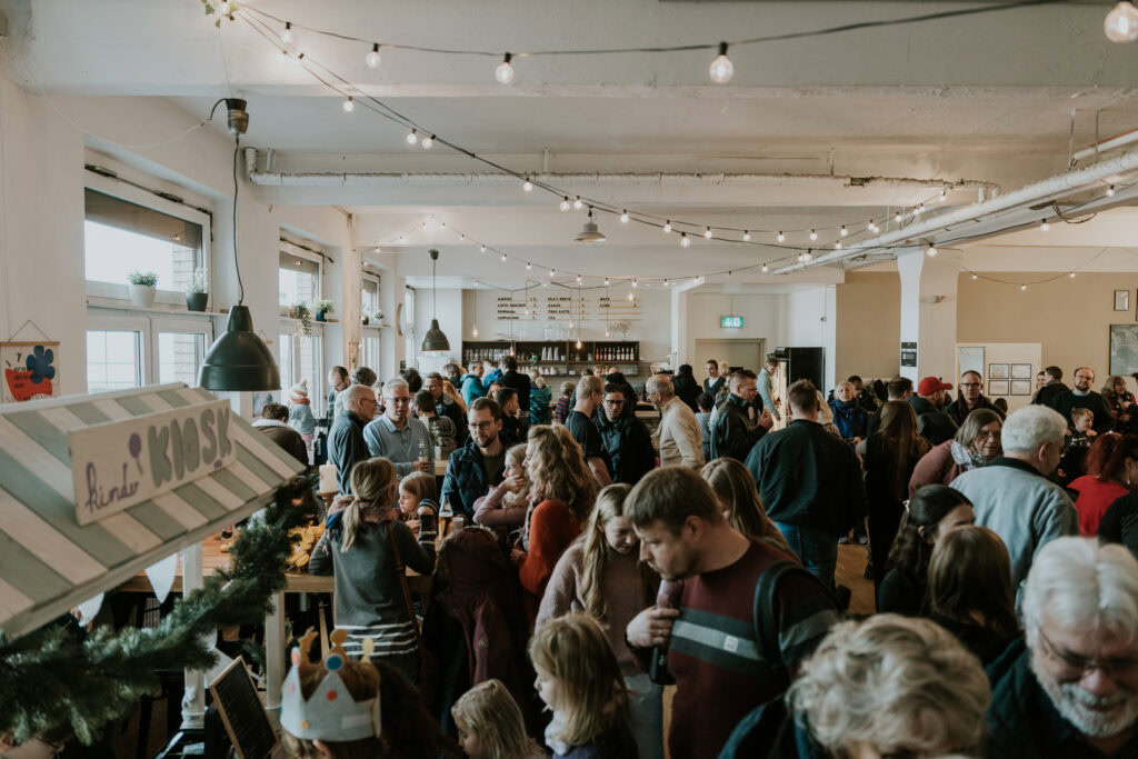 A vibrant community at ICF Berlin, where many people gather in a bright, modern event space to celebrate together and share their faith.