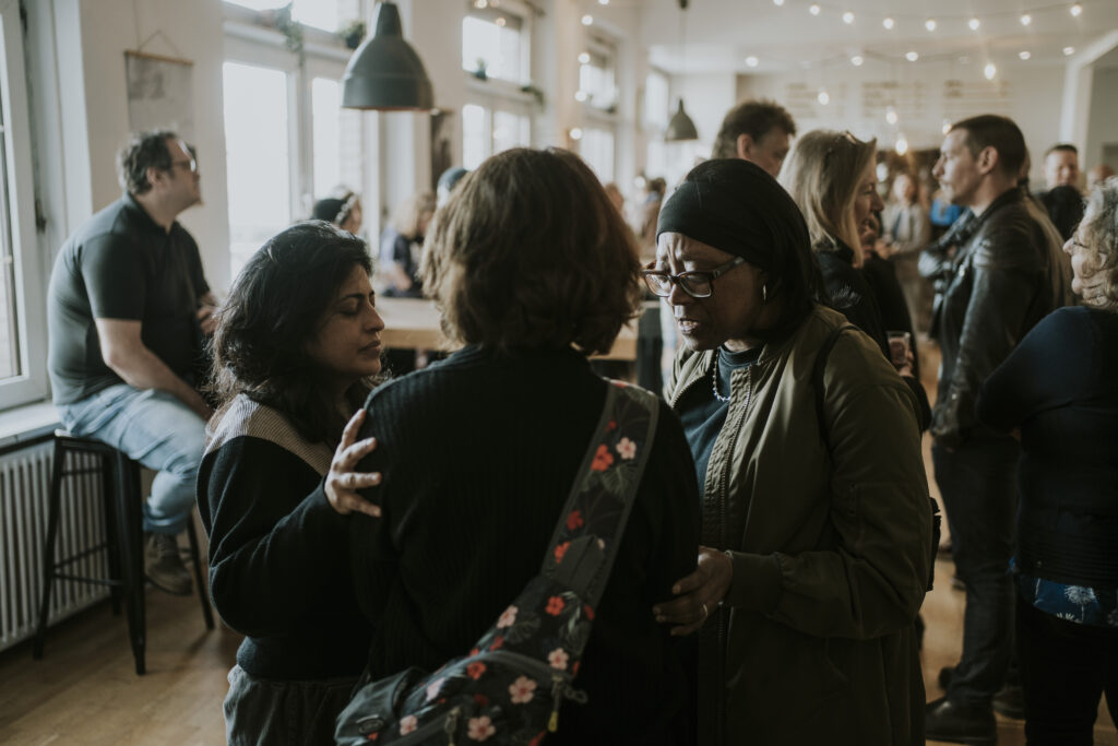People at a community evening at the ICF Berlin Church, interacting and connecting in a bright, modern space.