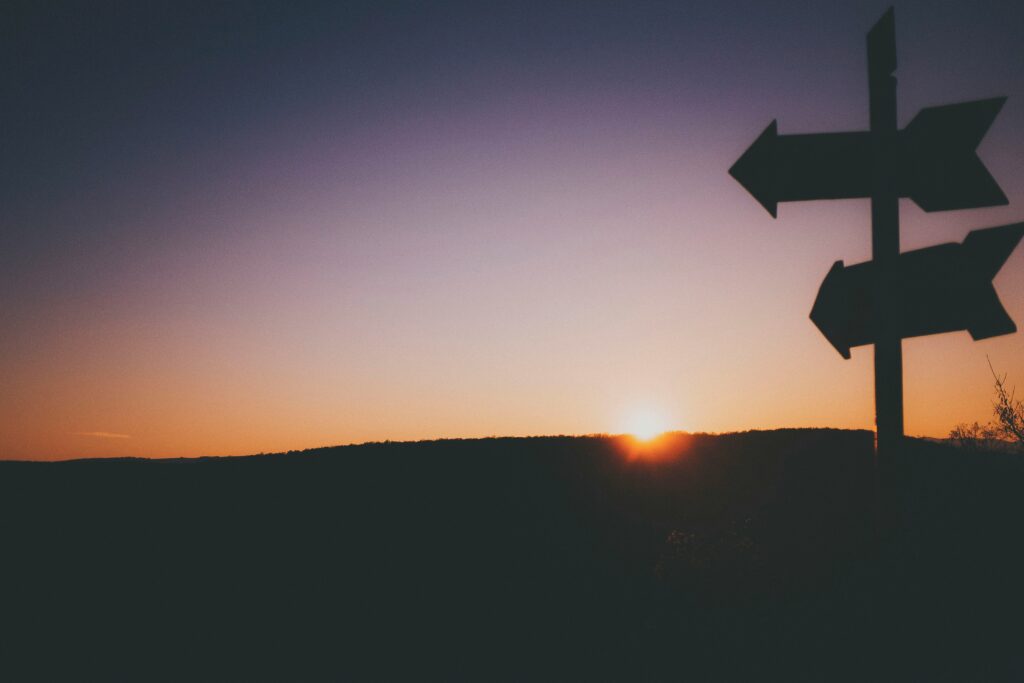 Schatten einer Wegweiser-Signalleitung vor Sonnenuntergang, zeigt Entscheidungshilfe bei Gemeindeaktivitäten und Gottesdiensten in Bern, Schweiz.