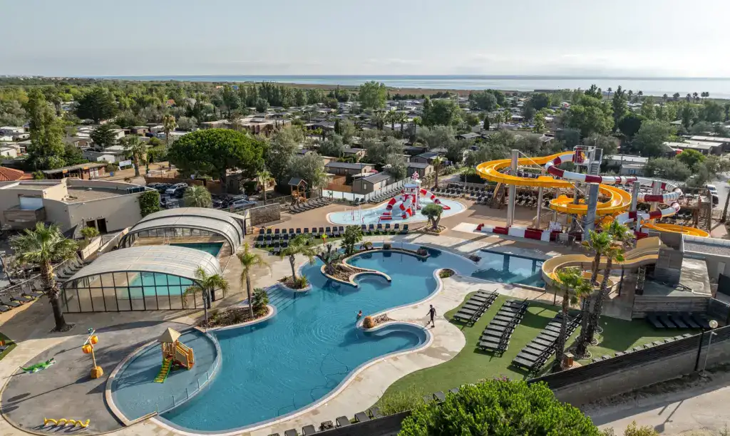Blick auf einen Wasserpark mit mehreren Wasserrutschen und einem großen Pool.
