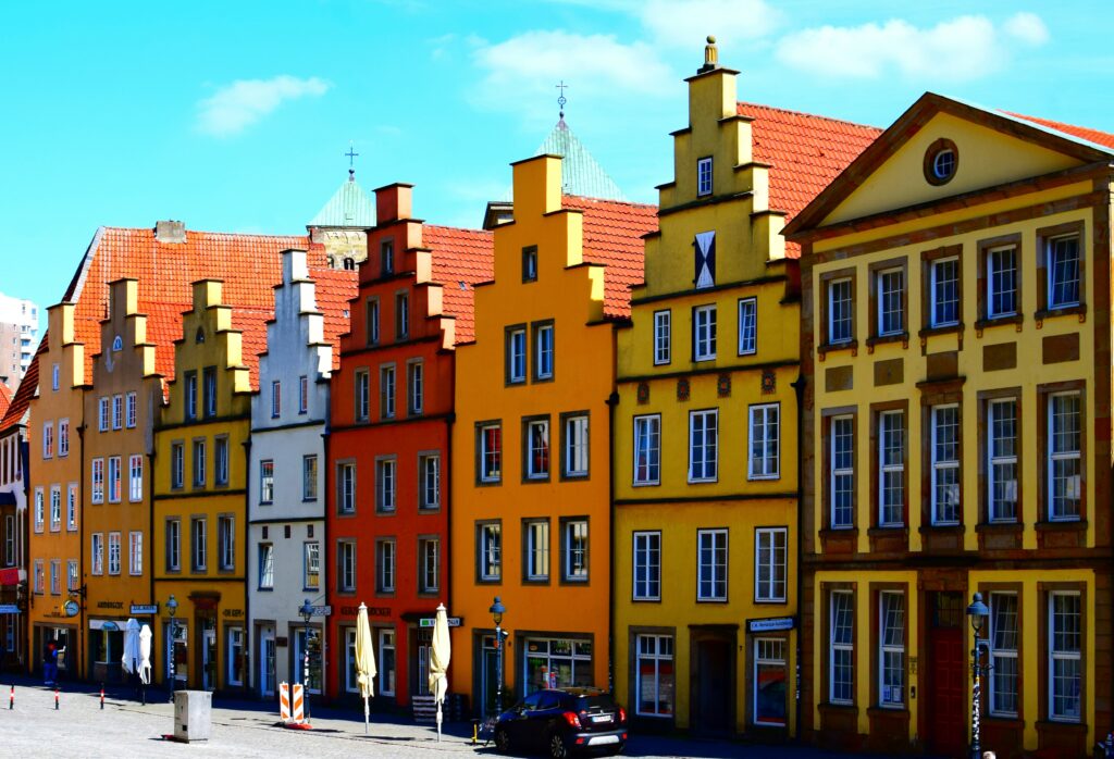 Bunte, alte Gebäude mit roten Dächern an einer Stadtstraße.