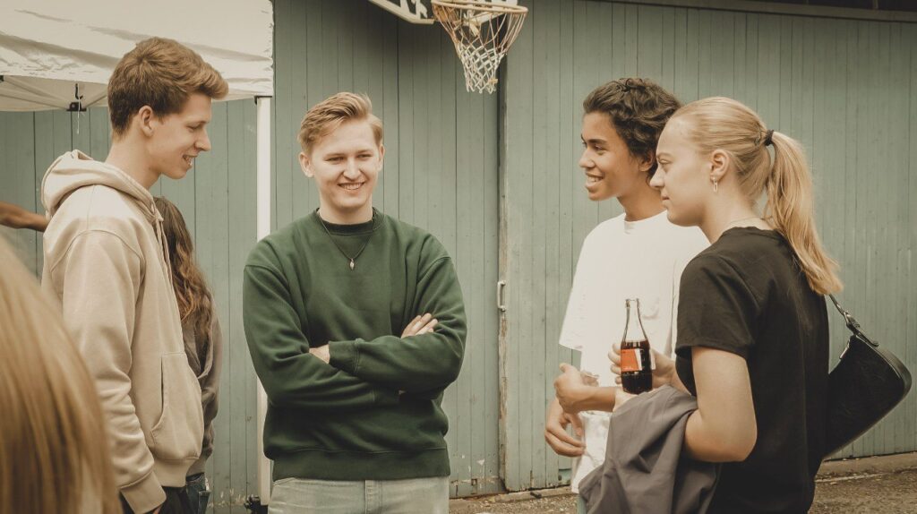 Junge Menschen im lockeren Gespräch bei einem Gemeinschaftsevent der Jugendgruppe in Essen. Freundschaft, Gemeinschaft und christliche Werte stehen im Mittelpunkt.