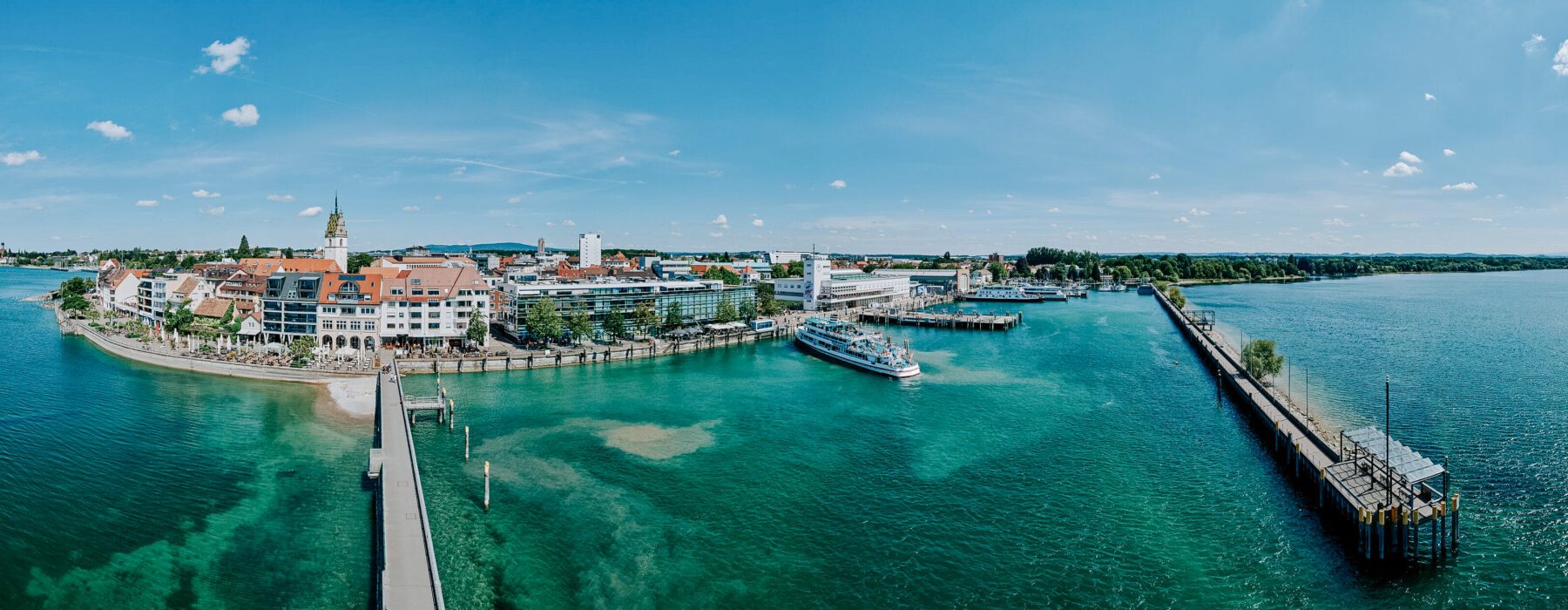 Hafen mit Stadt und Brücke bei Sonnenschein, Wasser und Gebäude.