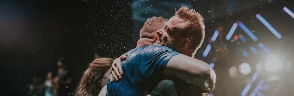 Two people hugging tightly, celebrating a moment of success.