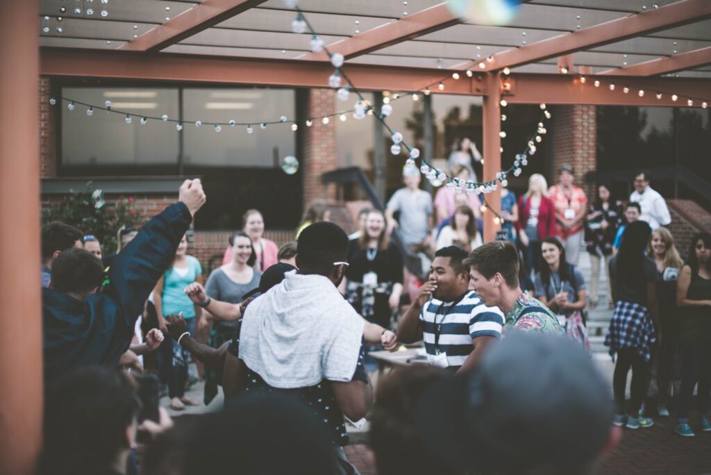 People dancing and socializing at an outdoor event.