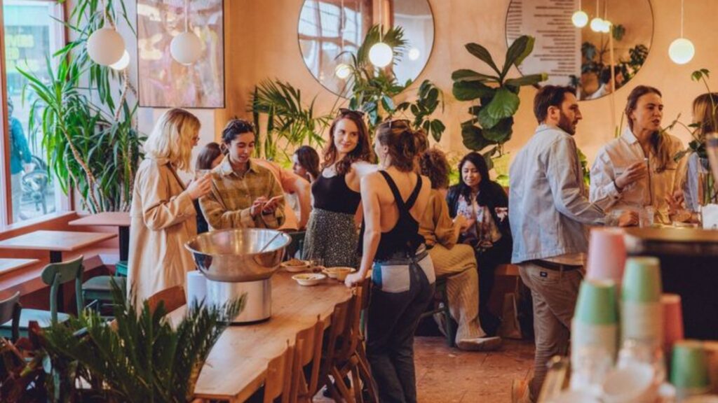 People gathered around a counter with drinks and food.