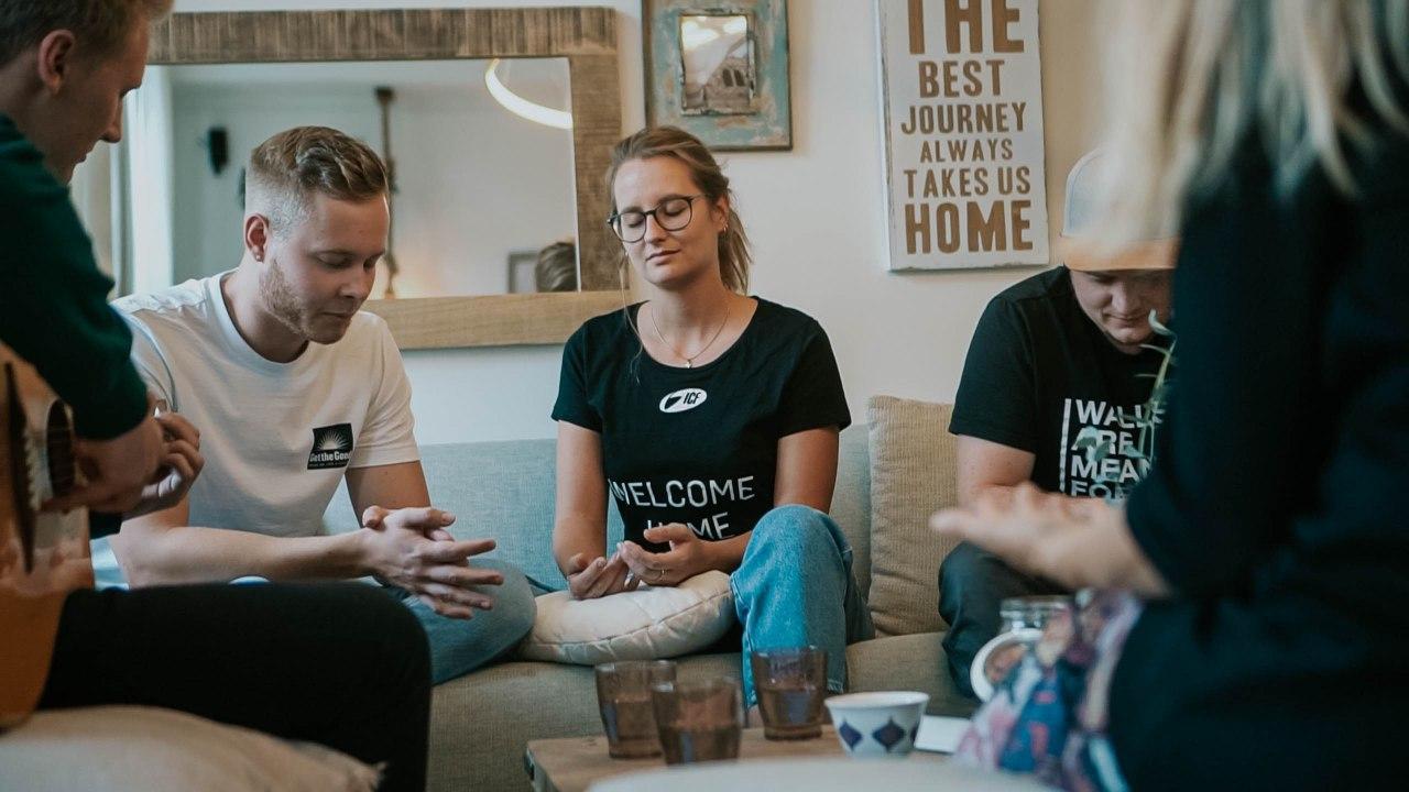 Vier Menschen sitzen auf einer Couch und sprechen miteinander.