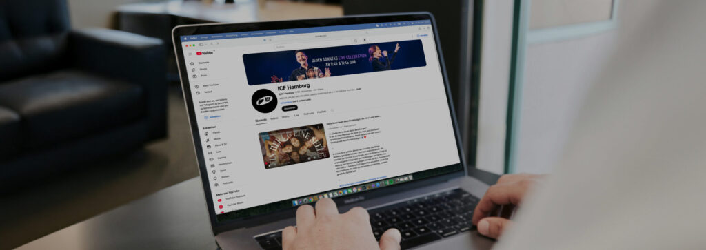 Person nutzt Laptop mit YouTube-Seite, sichtbarer Bildschirm mit Video-Thumbnail.