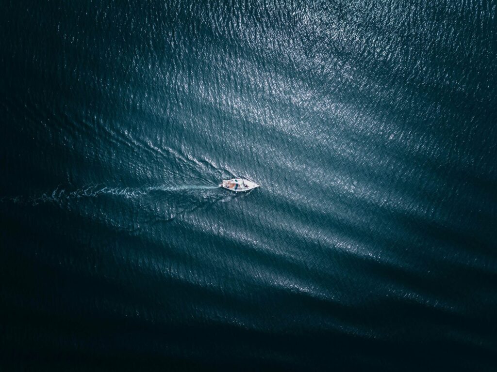 Ein kleines Boot auf dem Wasser, das Wasser ist dunkelblau.