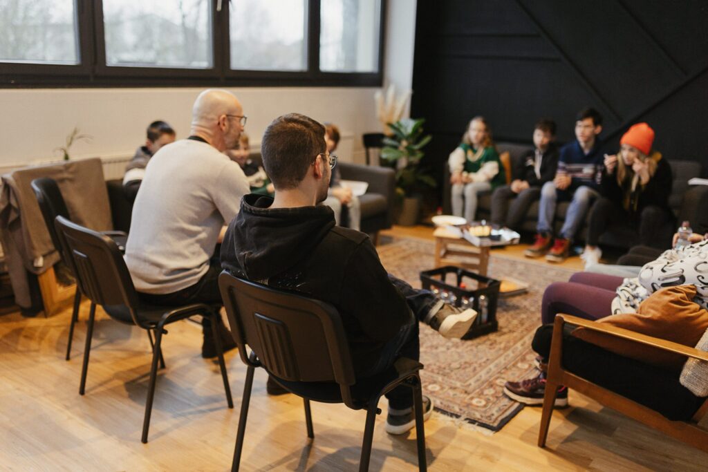 Gespräch mit jungen Menschen in einem modernen Raum, Hauskreis, Gemeindetreffen, Christliche Gemeinschaft, spirituelles Umfeld, Gemeinschaft in der Kirche, Jugendtreffen, Gottesdienst, Sharing.