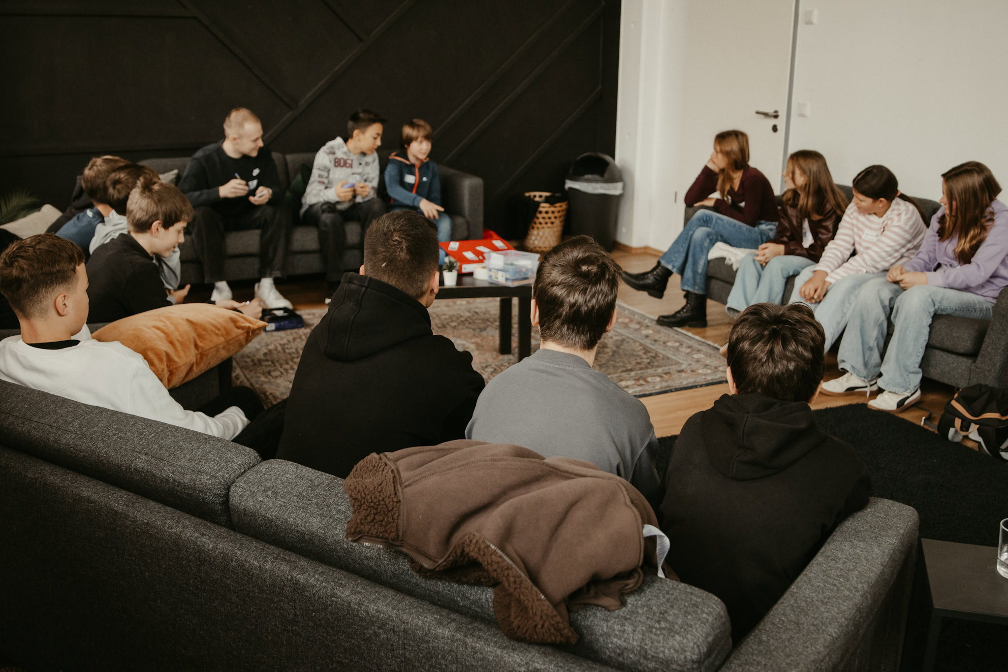 Inklusive Jugendtreffen mit jungen Menschen, entspannten Gesprächen und gemeinsamer Freizeitgestaltung in einer gemütlichen Wohnzimmer-Atmosphäre.