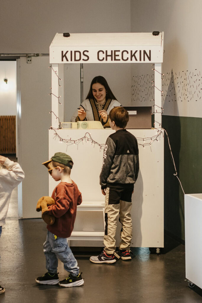Kinder-Check-in am Kids Check-in Schalter bei ICF Herrenberg. Fröhliche Kinder beim Anmelden für Kinderprogramm in einer freundlichen, einladenden Umgebung. Perfekt für Familien, die einen sicheren Or.