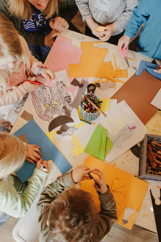Buntes Bastelprojekt mit Kindern, die Papier, Scheren und Farben verwenden, um kreative Kunstwerke zu gestalten. Perfekt für Kinderaktivitäten in der Gemeinde oder im Kindergarten.