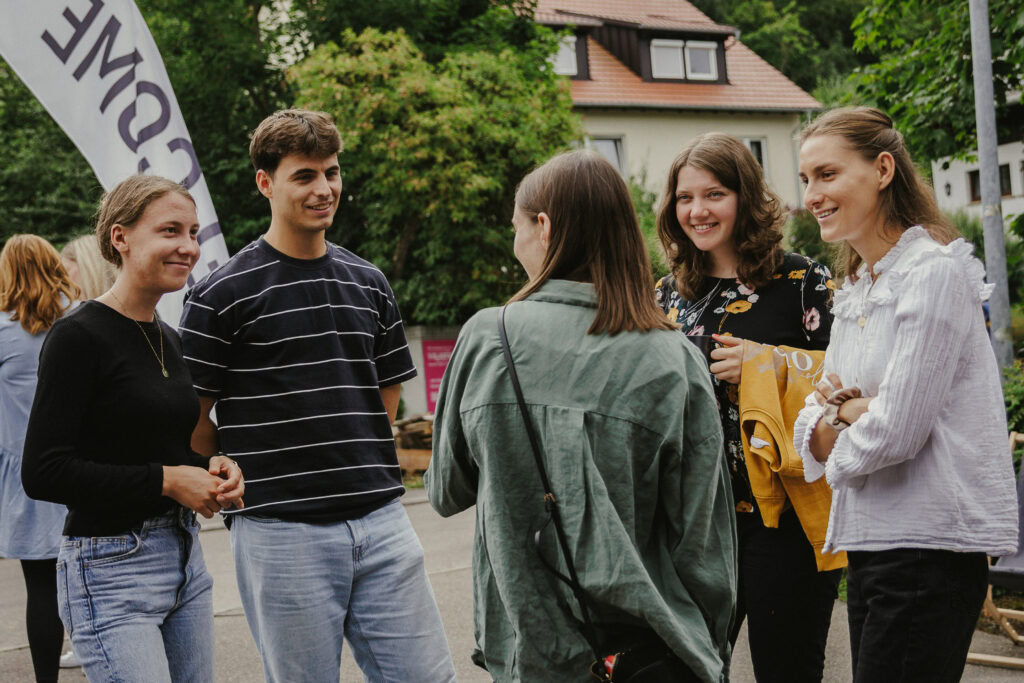 Junge Erwachsene im Gespräch bei einer Gemeinschaftsveranstaltung in Herrenberg, die den Zusammenhalt und die Verbindung innerhalb der Gemeinde fördert.
