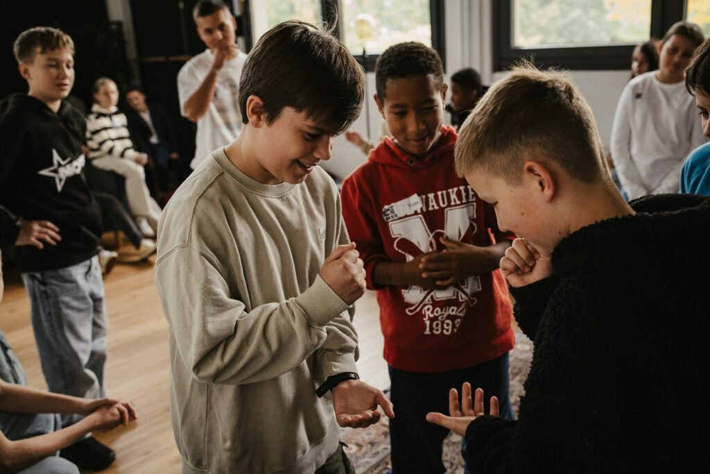 Children gathered in a room, some interacting and others observing.