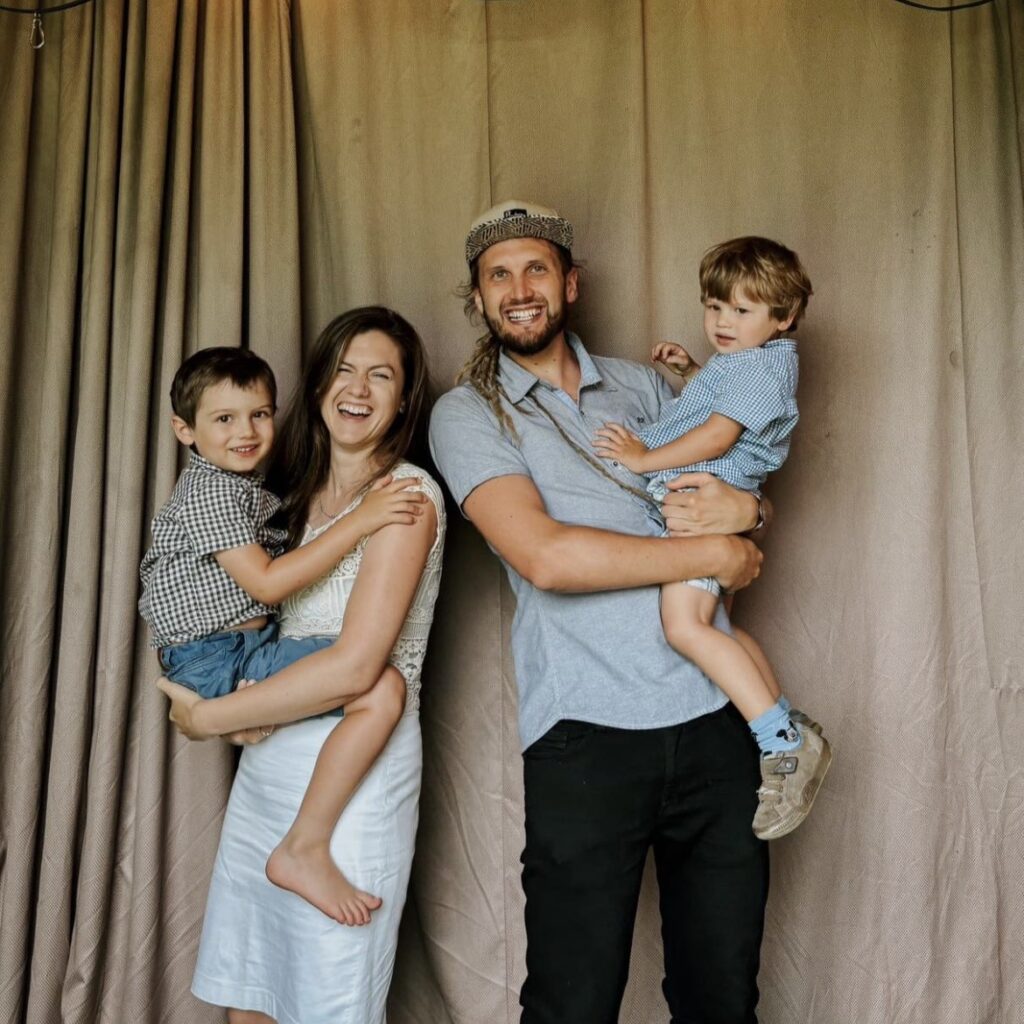 Familie mit Vater, Mutter und zwei Kindern vor Vorhang.