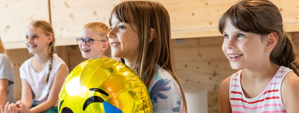 Kinder feiern Geburtstag, lachen und haben Spaß.