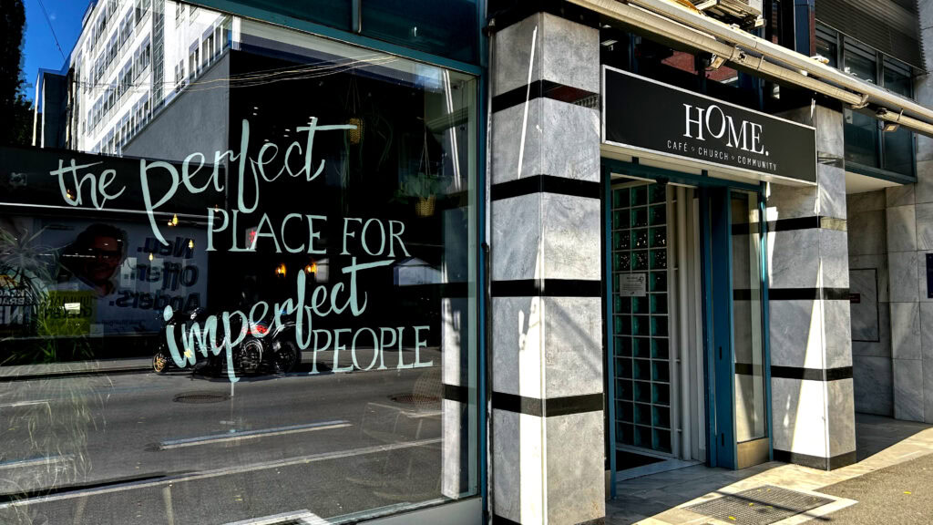 Schaufenster mit Schriftzug "the perfect place for imperfect people" vor einem Café.