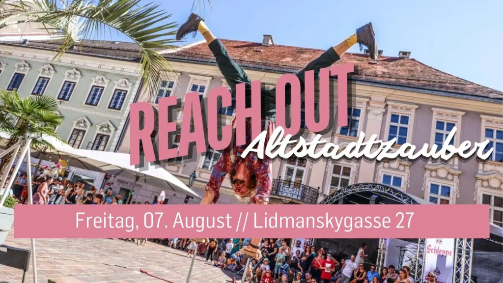 Person macht Handstand auf Stadtplatz mit Publikum im Hintergrund.