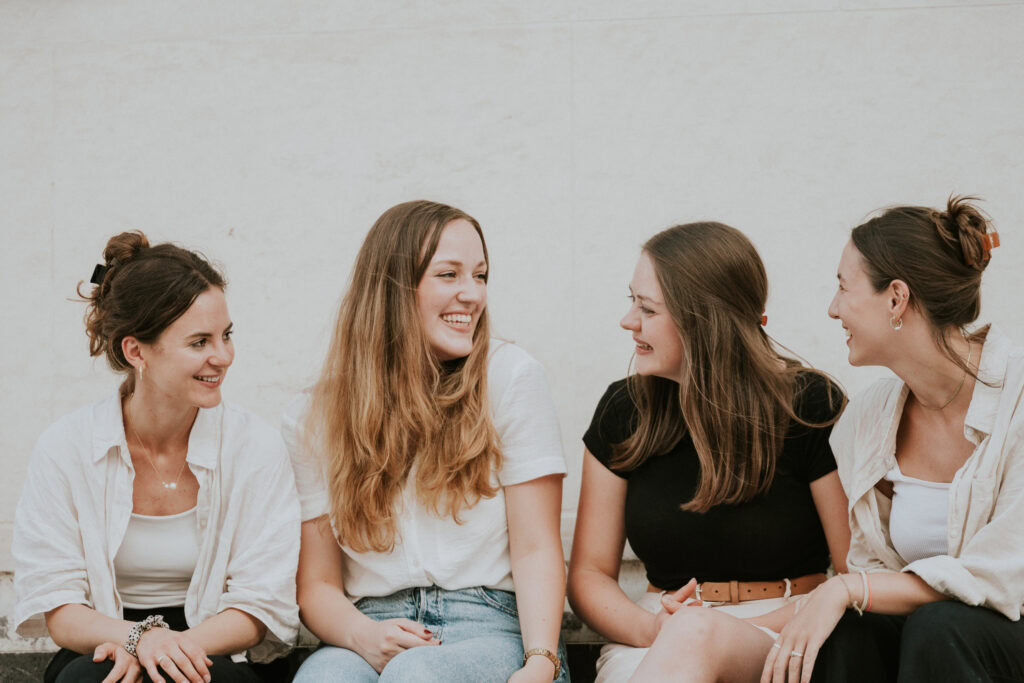 Fröhliche Frauen beim Gemeinschaftstreffen, lachen und sprechen, symbolisiert Verbundenheit und Gemeinschaft bei ICF, Fokus auf soziale Aktivitäten und freundschaftliche Beziehungen.