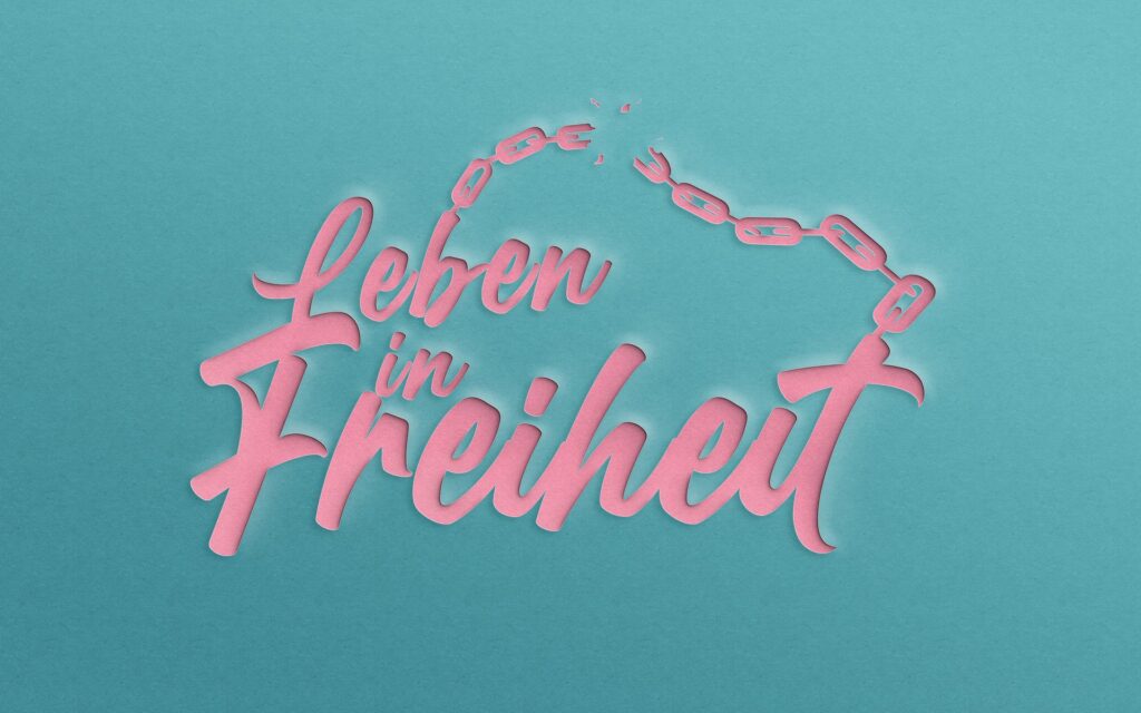 Pinkes Schriftzug "Leben in Freiheit" mit Kette auf blauem Hintergrund.