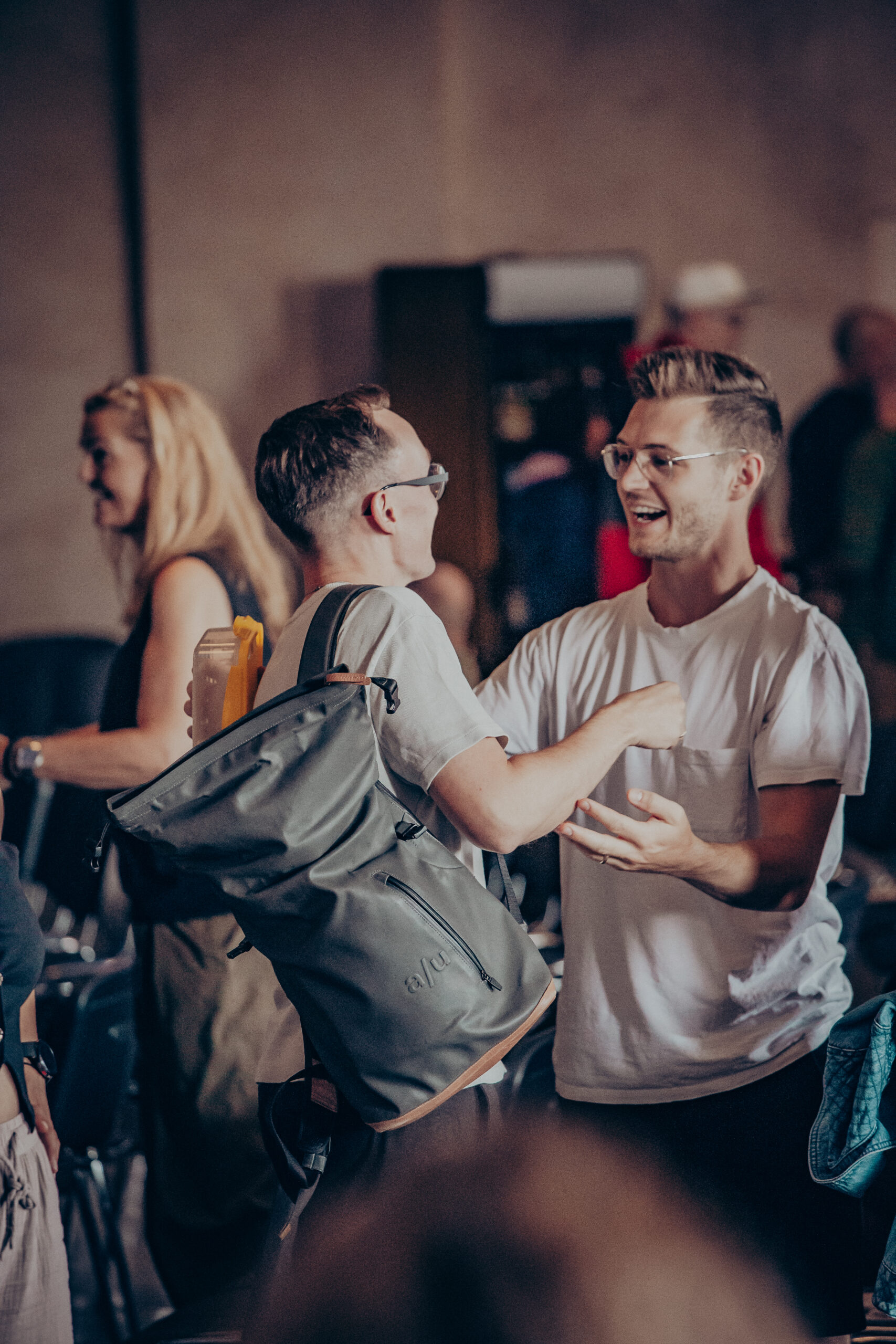 Glückliche junge Menschen lachen und feiern beim Treffen in Mannheim, zeigen Gemeinschaft, Freude und Zusammenhalt in modernem Kirchenambiente.