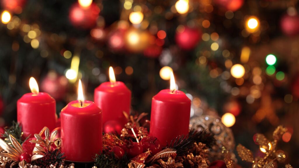 Vier rote Kerzen brennen auf einem Adventskranz.