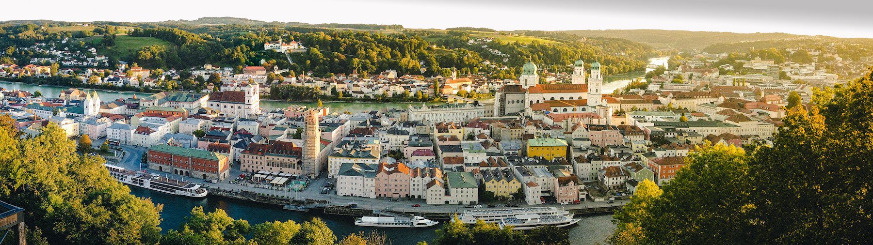 Passau Stadtpanorama mit Fluss und historischen Gebäuden bei Sonnenuntergang, Blick auf die Altstadt und den Inn, Donau und Ilz, in Bayern, Deutschland.