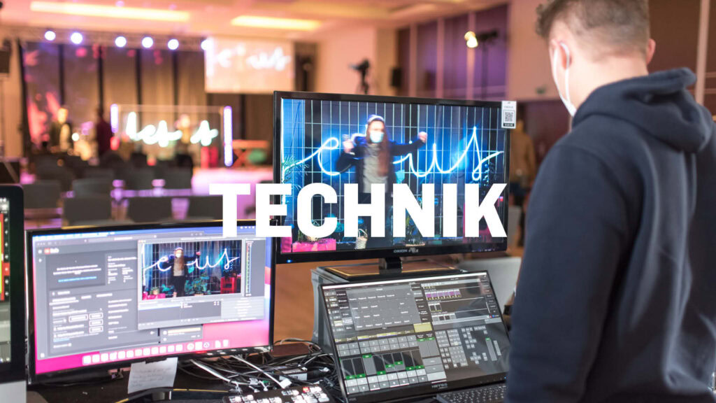 Ein junger Mann arbeitet an moderner Veranstaltungstechnik bei ICF Rhein-Main, mit mehreren Monitoren und Steuerungssystemen, um eine dynamische Kirche-Event-Atmosphäre zu schaffen.