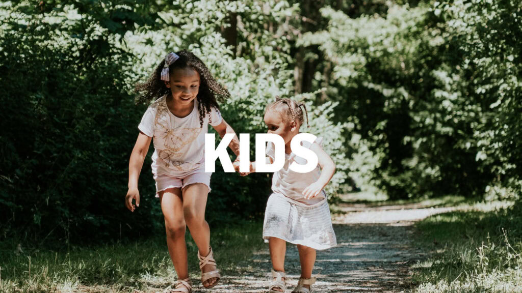Zwei lachende Kinder beim Spielen im Park, umgeben von Bäumen und Natur, ideal für Familien- und Kinderveranstaltungen in Rhein-Main.