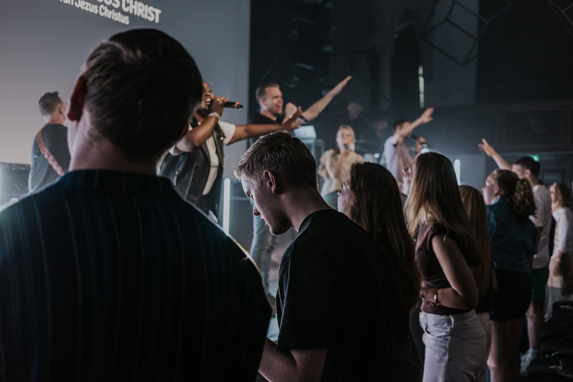 Mensen luisteren en zingen tijdens een religieuze dienst in een kerk.