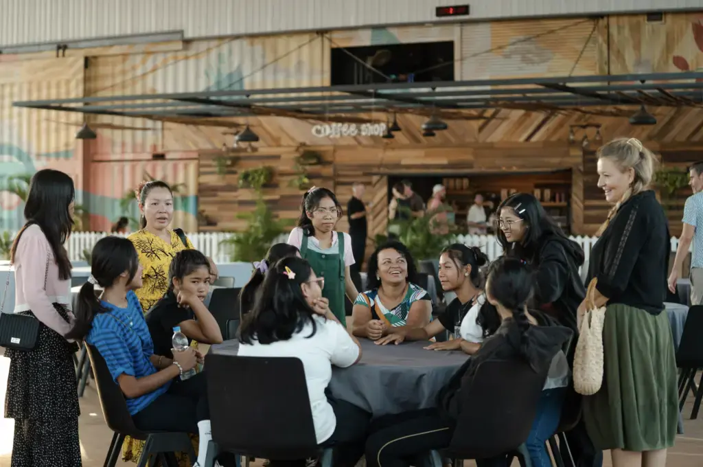 Gruppenfoto von ICF Siem Reap mit Menschen, die bei einer Gemeinschaftsveranstaltung im Freien sitzen und sich unterhalten.