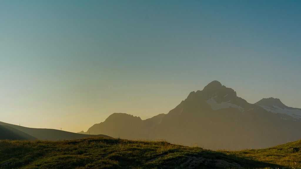 Eine Bergsilhouette bei Sonnenuntergang mit Himmel im Hintergrund.