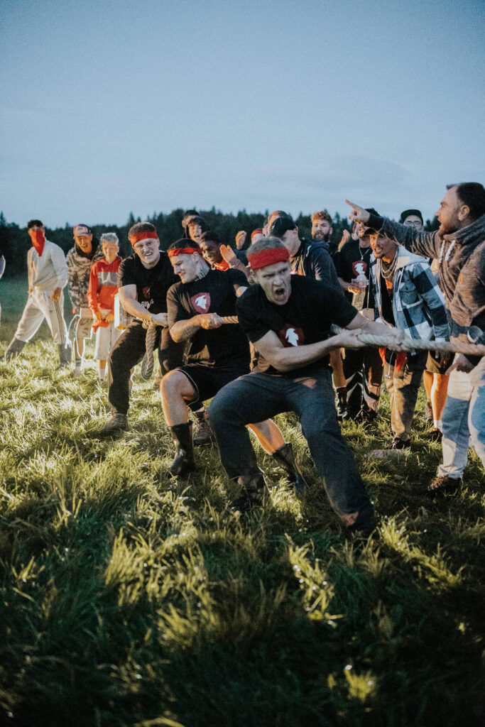 Gruppe von Menschen beim Seilziehen im Freien, Teamarbeit und Gemeinschaftsgeist bei ICF Schwarzwald Bodensee.