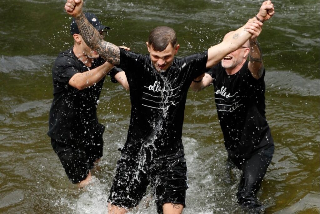 Drei Menschen tauchen im Wasser bei ICF Schwarzwald Bodensee, feiern gemeinsam und zeigen Gemeinschaftssinn. Perfekt für christliche Veranstaltungen und Glaubensgemeinschaften.
