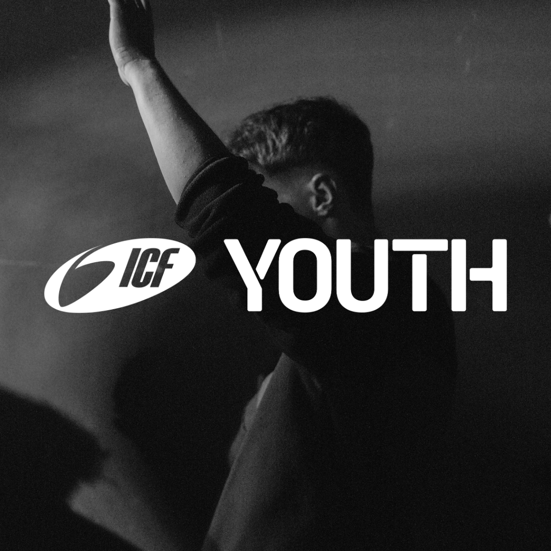 High-quality black-and-white photo of a young man with his hand raised, symbolizing hope, community, and spiritual connection within the ICF youth group.