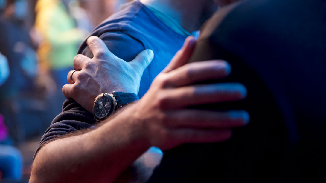 Zwei Menschen mit verschränkten Händen auf der Brust, eine Person trägt eine Armbanduhr.