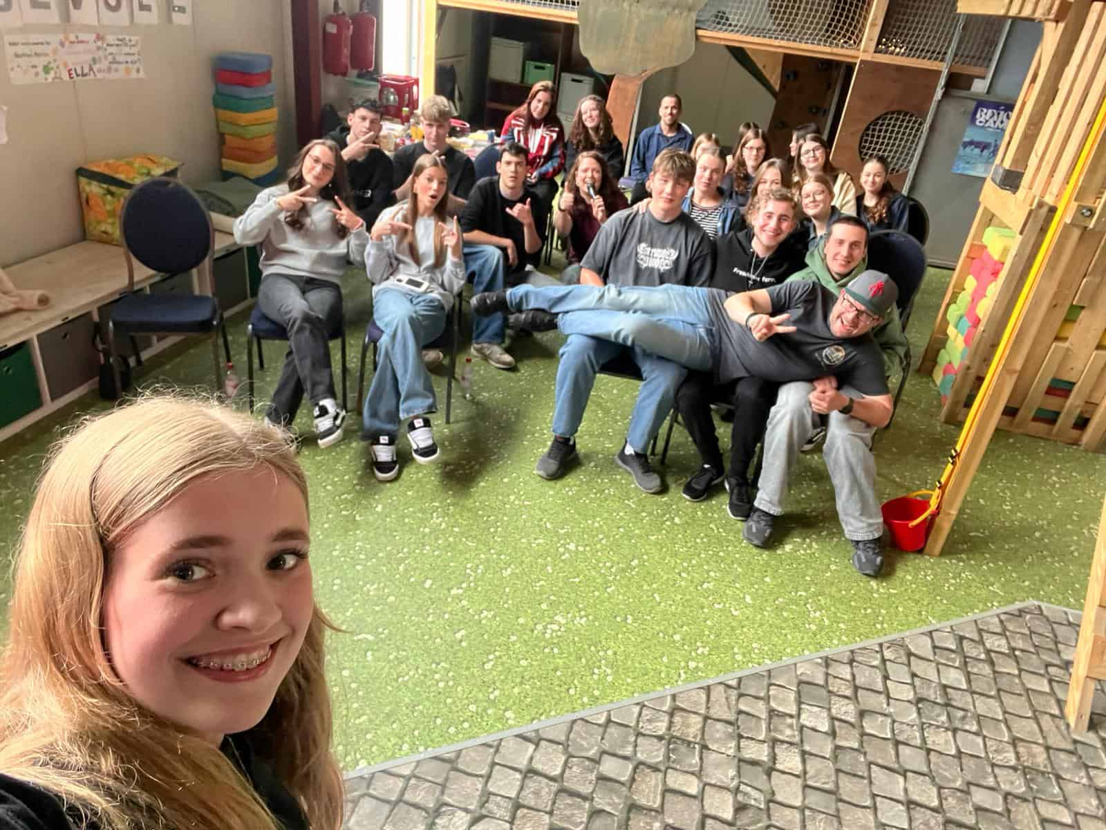 Jugendliche und junge Erwachsene der ICF Wetzlar beim Treffen in einem Gemeinschaftsraum, lachend und gemeinsam Spaß habend.