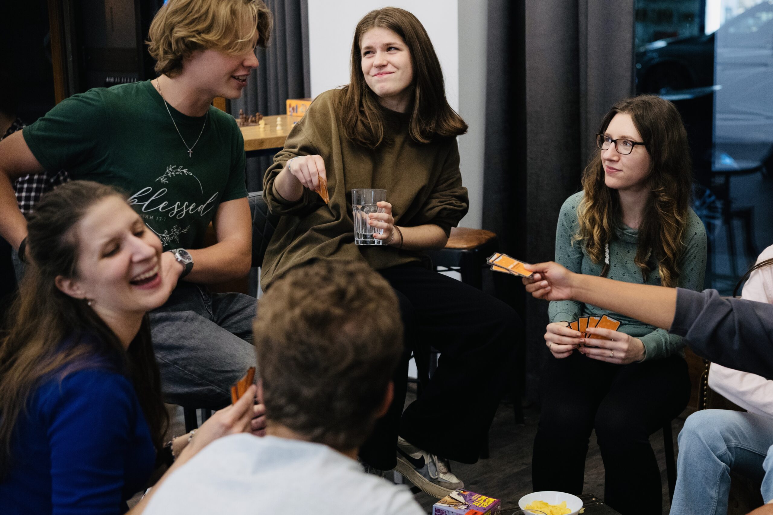 Vier Jugendliche sitzen in einem Raum, unterhalten sich und lachen.