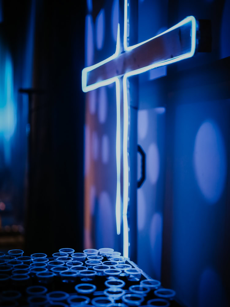 Neon-Gottesdienst-Leuchtreliquie an einer Wand, blauer Lichtschein.